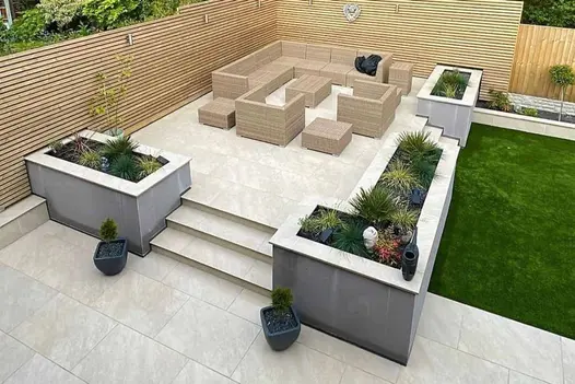 Outdoor seating area with planters, fully paved in White Quartz 1200x600 porcelain tiles.