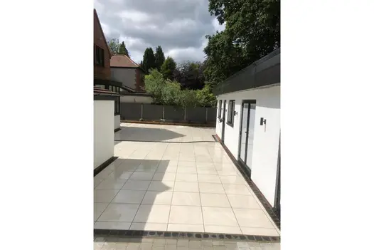 Patio featuring Allora Bianco 600x600mm porcelain paving, in a uniform pattern to create a clean modern aesthetic.