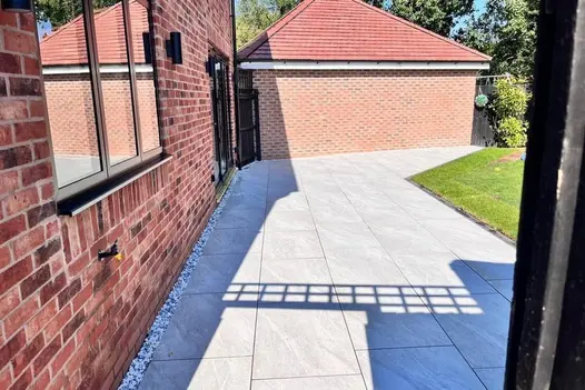 A beautifully designed outdoor space with County Light porcelain paving, blending seamlessly with lush greenery.
