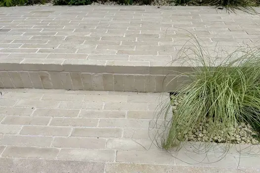 Beige Sandstone Brick Pavers used on garden steps and terraces, with matching risers and a planted gravel border.