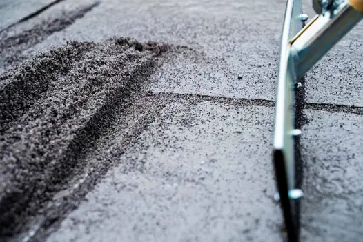 A close up image of JointTec jointing compound being brushed into paving joints during installation.
