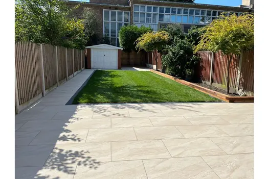 Contemporary garden design with County Cream Porcelain Paving and neat lawn, surrounded by fencing.