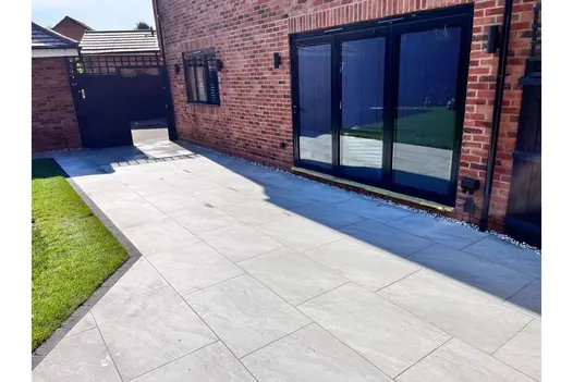 A contemporary patio paved with County Light 900x600 porcelain slabs, offering a light and airy feel.