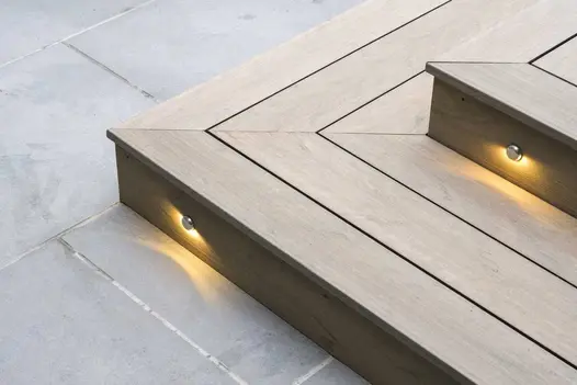 Close-up of DesignBoard fascias used on garden steps, shown with integrated step lighting and smooth contemporary paving.