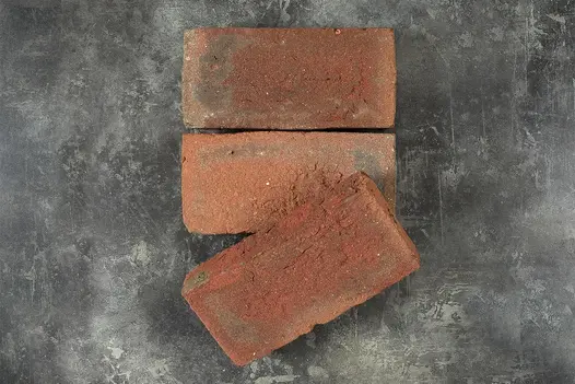 Two Dorset Antique Clay Paver Bricks with third placed at an angle, view from above on dark background.