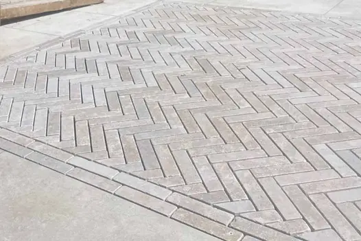 Herringbone pattern patio using Egyptian Beige Limestone brick pavers with soft beige and taupe tones.