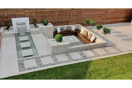 Modern garden design uses Gaja Beige 900x900 Porcelain Paving, in a stepping-stone style with gravel and sunken seating area.