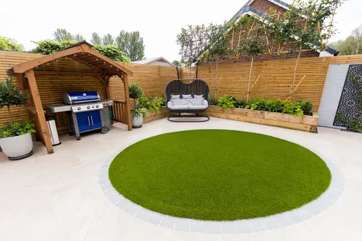 Family garden design featuring Gaja Beige Porcelain, circular lawn and wooden pergola with barbecue area.