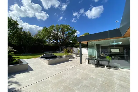 Spacious garden design using Heritage Chalk 900x600 Patio Tiles, with linear layout and matching modern raised planters.