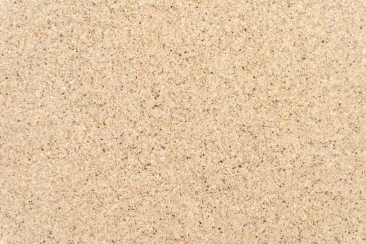 A close-up of golden-coloured JointTec brush-in jointing compound, showing its sand-like granules.