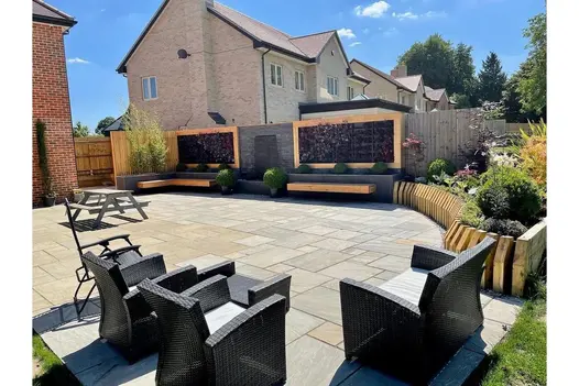 Modern garden layout featuring Kandla Grey sandstone paving, with a cosy seating area and raised flowerbeds.