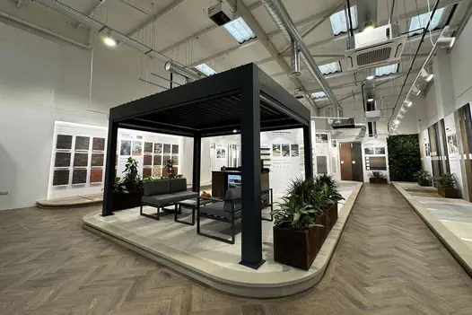 Deluxe Metal Pergola in a showroom setting, showcasing sleek anthracite grey finish and adjustable roof louvres.