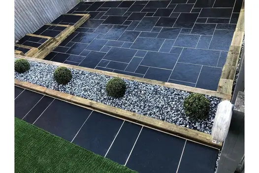Midnight Black Limestone paving set in stylish design with contrast of dark slabs and a light gravel.