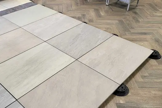 Organic-looking tones of Raj Green Porcelain Paving on pedestals at our North London Showroom. Showing the beauty of these Garden Tiles UK.