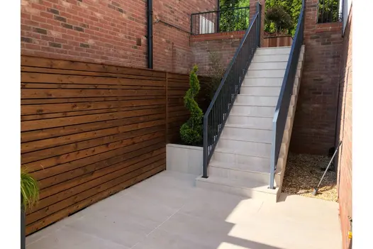 Clean lines and minimalist planting line this garden stairway, finished in Overland Sand 900x450 Porcelain Paving.