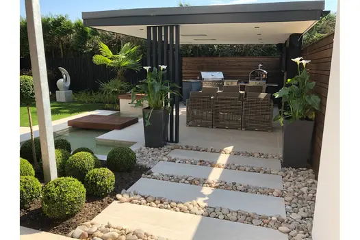 A structured gravel path with Overland Sand Porcelain stepping stones leads to a covered outdoor area.