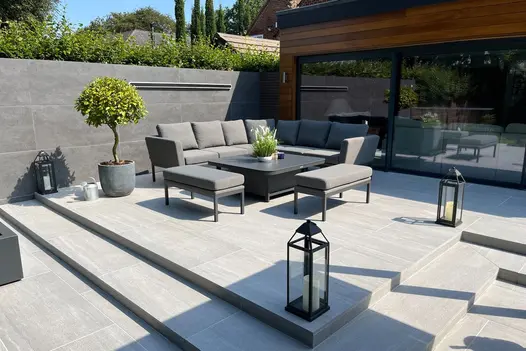 Modern garden lounge setup using Overland Silver paving, with split-level steps and contemporary decor.