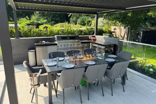 Alfresco kitchen and dining zone on Overland Silver Porcelain Paving, styled for outdoor entertaining.