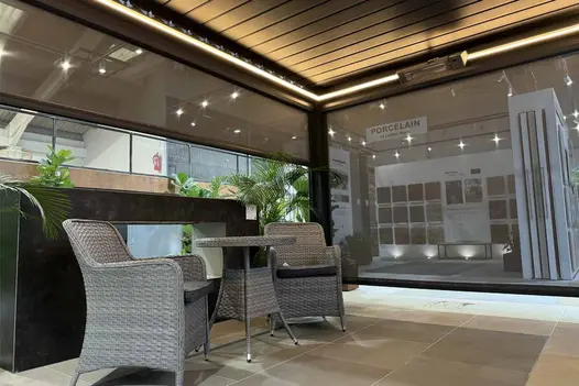 Deluxe Anthracite Grey 4x3 Metal Pergola with remote-controlled roof louvres and blinds partially opened in showroom setting.