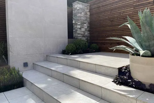 Multi-level garden design with 900x450 pumice porcelain paving and built-in planters.