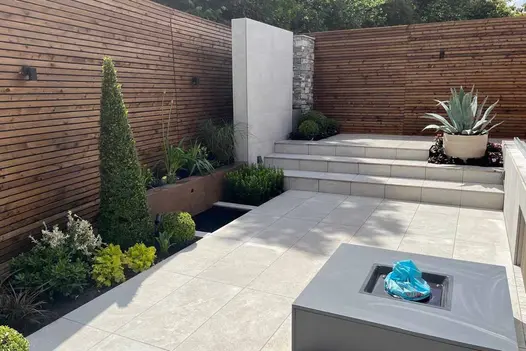 Contemporary garden patio laid with pumice porcelain paving in a clean 900x450 format.