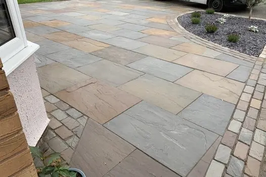 Driveway paved in Raj Green Indian Sandstone 900x600, showing natural blends of browns, greys and green tones with a riven texture.